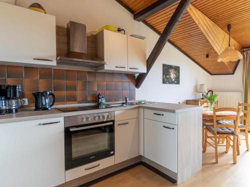 a kitchen with white cabinets and a stove top oven at Apartment Nordsee-Ferienhaus-1 by Interhome in Friedrichskoog