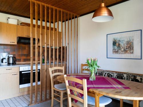a kitchen and dining room with a wooden table and chairs at Apartment Nordsee-Ferienhaus-2 by Interhome in Friedrichskoog