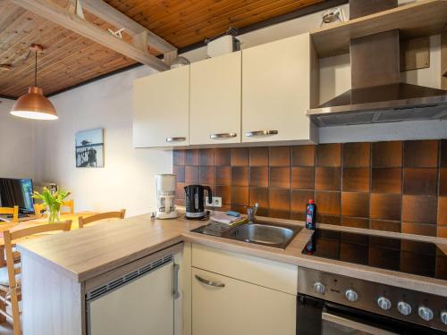 een keuken met witte kasten en een wastafel bij Apartment Nordsee-Ferienhaus-5 by Interhome in Friedrichskoog