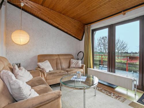 a living room with two couches and a glass table at Apartment Nordsee-Ferienhaus-4 by Interhome in Friedrichskoog