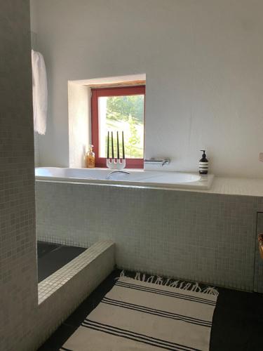 a bathroom with a tub and a sink and a window at Casa Goikomaia in Arrázola