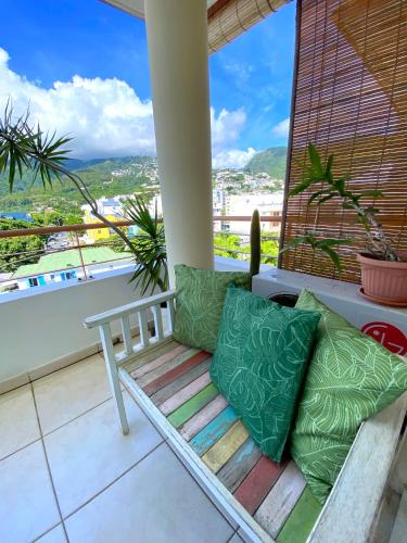 a porch with a bench and pillows on a balcony at Appartement lumineux et calme Saint-Denis centre in Saint-Denis