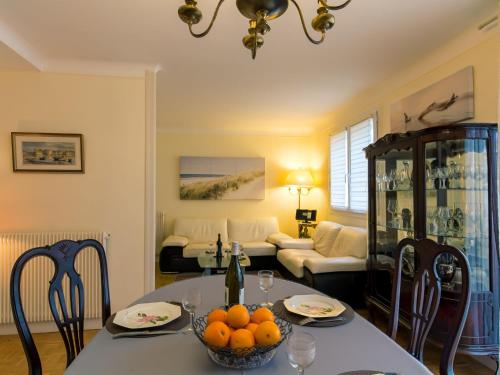 una sala de estar con una mesa con naranjas. en Apartment Les Glénans - CCN113 by Interhome, en Concarneau