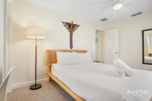 ein Schlafzimmer mit einem Bett und einem Kreuz an der Wand in der Unterkunft Walk to Lady Bird Lake from Perfectly Quaint Home in Austin