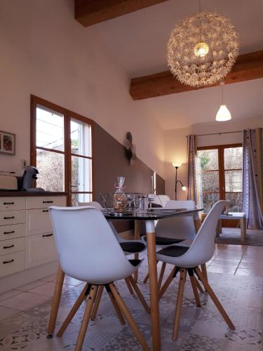 une salle à manger avec une table et des chaises blanches dans l'établissement Pégase, à Fa