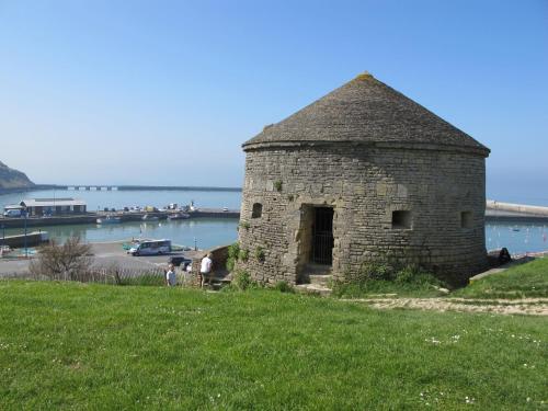 an old stone building on the side of a grass field at Holiday Home Le Clos Renard by Interhome in Commes