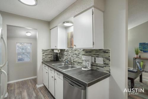 a kitchen with white cabinets and a sink at Everything You Need Near S Lamar Perfect Condo in Austin