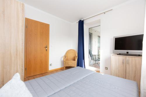 ein Schlafzimmer mit einem Bett und einem Flachbildfernseher in der Unterkunft Strandnixe 301 in Döse