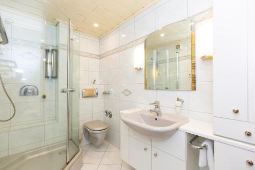 ein Badezimmer mit Dusche, Waschbecken und Toilette in der Unterkunft Strandnixe 301 in Döse