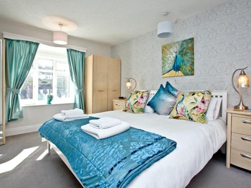 um quarto com uma grande cama branca com lençóis azuis em Bishopsgate em Torquay