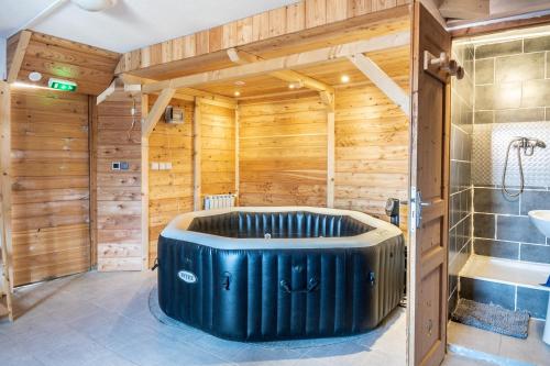 una grande vasca in un bagno con pareti in legno di Maison de 12 chambres avec sauna terrasse amenagee et wifi a Vars a 2 km des pistes a Vars