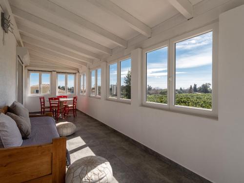 a living room with windows and a table with chairs at Holiday Home La Cerisaie - MNI260 by Interhome in Santa-Lucia-di-Moriani