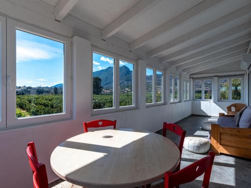 une salle à manger avec une table, des chaises et des fenêtres dans l'établissement Holiday Home La Cerisaie by Interhome, à Santa-Lucia-di-Moriani