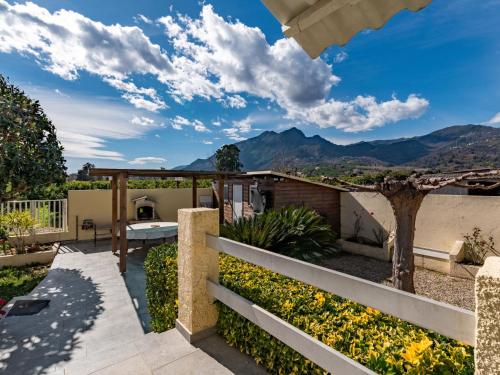 a view from the backyard of a house with mountains in the background at Holiday Home La Cerisaie - MNI260 by Interhome in Santa-Lucia-di-Moriani