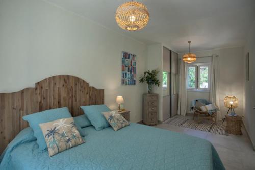 - une chambre avec un lit bleu et une tête de lit en bois dans l'établissement MAISONS BORD DE MER- MARINE DE SORBO - Gîtes 3 épis, à Pinarellu