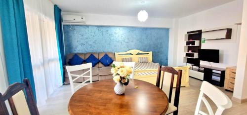 een woonkamer met een tafel en een slaapkamer bij Big & Cosy Apartment with 3 double beds by Evelyn Apartments in Iaşi