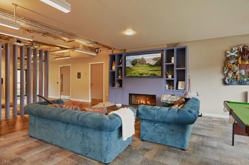 a living room with two blue couches and a fireplace at For Students Only Combworks at Aberdeen in Aberdeen