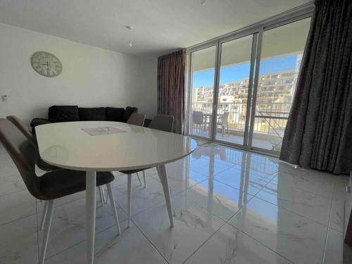 uma sala de jantar com uma mesa e vista para um edifício em 2 bedroom Apartment in Mellieha with Sea Views and Close to all Amenities em Mellieħa