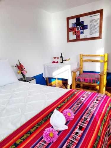 a bedroom with a bed and a table with at Amantani Lodge in Amantani