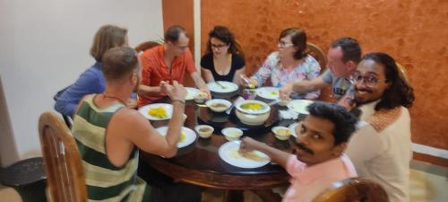 a group of people sitting around a table eating food at Maliyeckal Homestay in Munnar