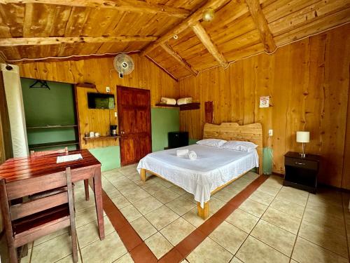una camera con letto e scrivania di Hotel de Montaña El Pelicano a San Isidro de El General