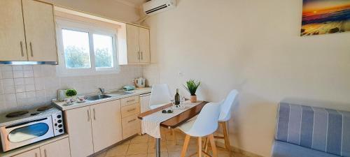 a kitchen with a table and chairs and a sink at Sidari Vibes On The Beach in Sidari