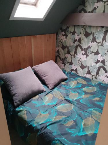 a bed with two pillows on it in a room at Vakantieverhuur Noordwolde in Noordwolde