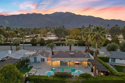 uma vista aérea de uma casa com palmeiras e montanhas em The Ritz - Luxury Home with Pool & Speakeasy Bar em Palm Springs