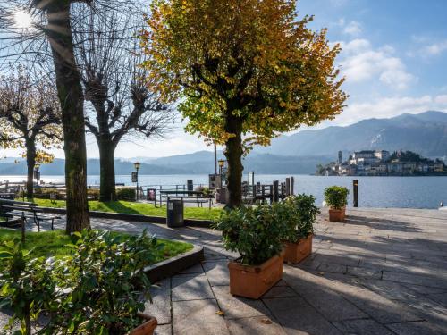 a group of trees on a sidewalk near the water at Holiday Home Monte San Giulio by Interhome in Pella
