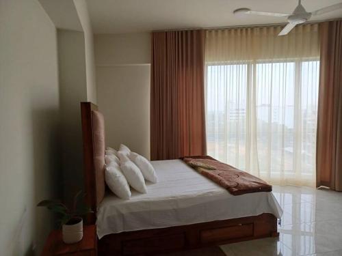 Schlafzimmer mit einem Bett und einem großen Fenster in der Unterkunft Luxury 3 Bedrooms Apartment in Colombo in Sri Jayewardenepura Kotte