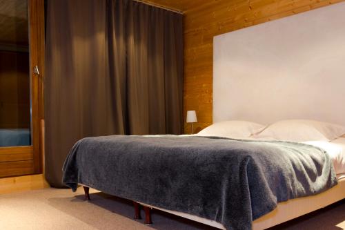 a bedroom with a bed with a gray blanket on it at La Résidence Belledonne in Courchevel