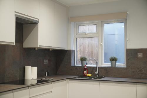 a kitchen with white cabinets and a window at Lux 3BDR for 7 nr London Eye in London