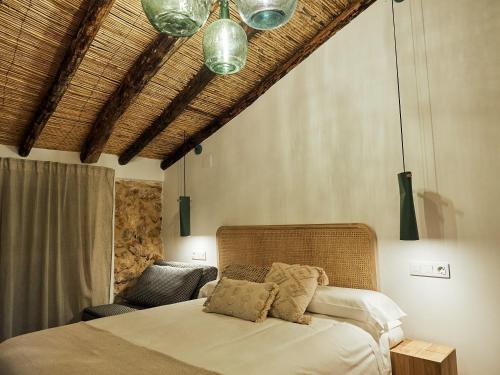 a bedroom with a bed and a chandelier at LIGNUM Casa Rural in Ayna