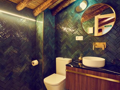 La salle de bains est pourvue d'un lavabo, de toilettes et d'un miroir. dans l'établissement LIGNUM Casa Rural, à Ayna