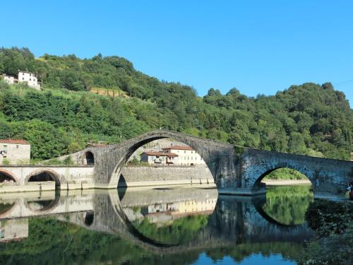 a bridge over the water with houses and trees at Holiday Home Belvedere - BLU101 by Interhome in Bagni di Lucca