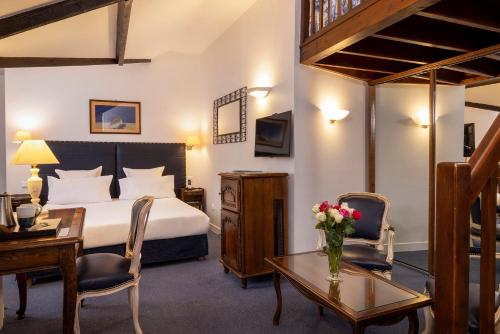 une chambre d'hôtel avec un lit, une table et des chaises dans l'établissement Relais Hôtel du Vieux Paris, à Paris