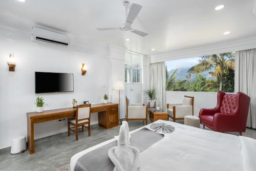 a hotel room with a bed and a desk at HOTEL WHITE HOUSE, Munnar in Munnar
