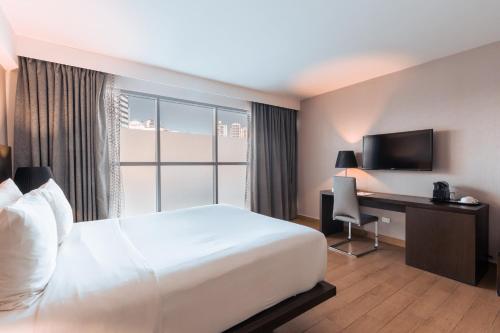 Una cama o camas en una habitación de Exe Oriental Panamá