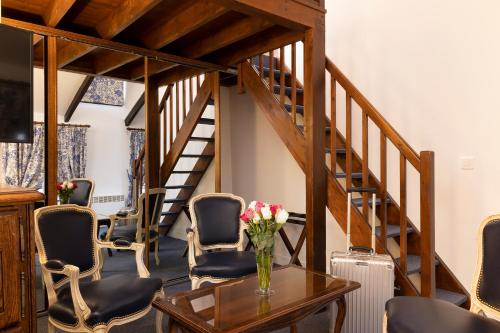 a room with chairs and a table and stairs at Relais Hôtel du Vieux Paris in Paris