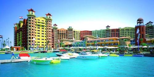 a group of boats docked in a harbor with buildings at Porto marina chalet and apartment in El Alamein