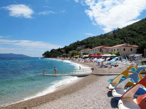a beach with a bunch of people and the ocean at Apartment Branka-1 by Interhome in Mošćenice