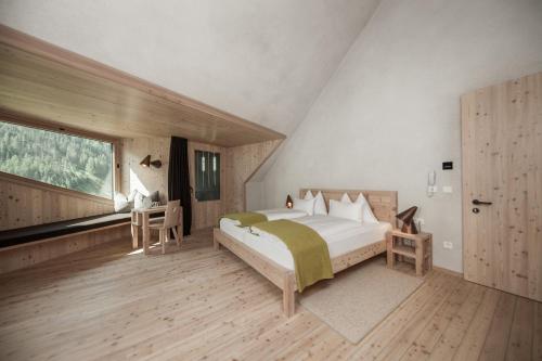a bedroom with a large bed and a large window at Bühelwirt in San Giacomo