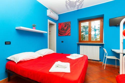 una camera blu con un letto rosso e asciugamani di Affittacamere Grugliasco Ressia a Grugliasco