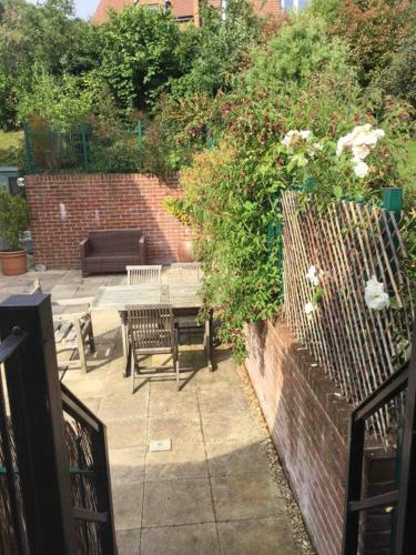 a patio with a table and chairs and a fence at Oak Loft in Lyme Regis