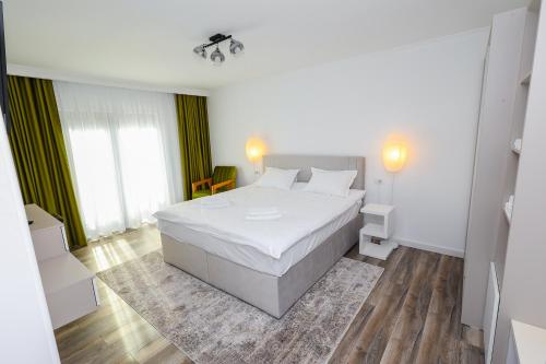 a bedroom with a white bed in a room at Bucovina Flower in Câmpulung Moldovenesc