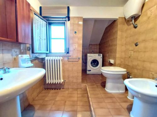 a bathroom with a sink and a toilet and a washing machine at CENTRO, WIFI, CLIMA a DUE PASSI DAL MARE in Porto San Giorgio