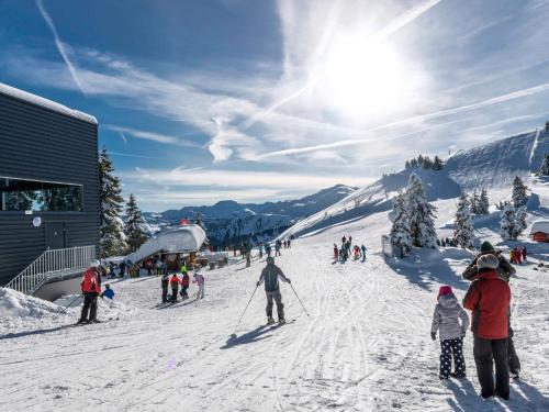 a group of people skiing down a snow covered slope at Apartment Sonnseit Living by Interhome in Oberau