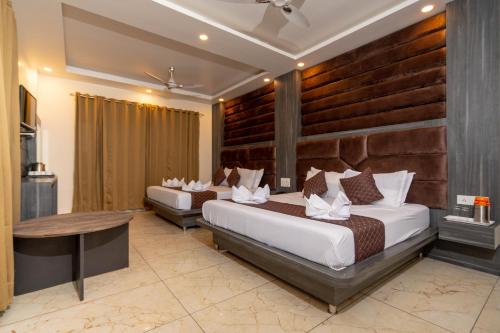 a hotel room with two beds and a table at Hotel The Vaishvik in Katra