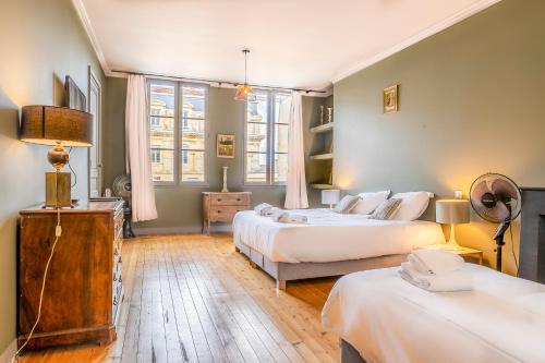 1 dormitorio con 2 camas y mesa con lámpara en Magnifique appartement en Hypercentre, en Burdeos