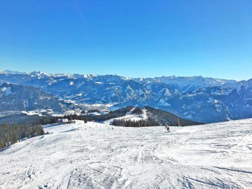 a group of people skiing down a snow covered mountain at Apartment Alpenchalets-4 by Interhome in Zell am See